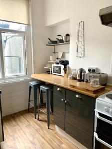 a kitchen with a counter with stools in it at Seaview Richmond Terrace in Swansea