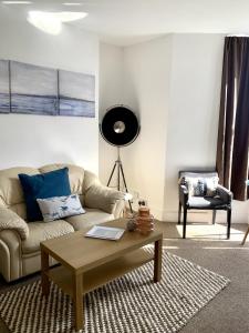 a living room with a couch and a coffee table at Seaview Richmond Terrace in Swansea