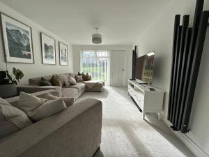 a living room with a couch and a flat screen tv at Spacious and stylish 3-bed home ideal for families in Stockton-on-Tees