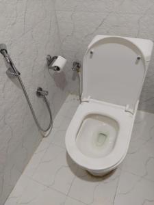 białą toaletę w łazience z rolką papieru toaletowego w obiekcie Hotel Sauraha Gaida House w mieście Chitwan