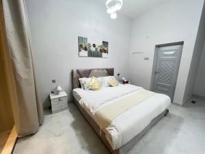 alsaif camp في Badīyah: غرفة نوم بسرير كبير مع شراشف بيضاء