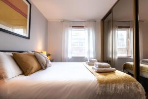 1 dormitorio con 1 cama grande con sábanas y almohadas blancas en Black Moon -2-bed,2-bath - Central location- Southampton, en Southampton