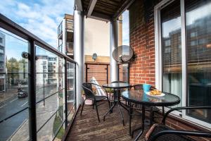 Un balcón con 2 mesas y sillas en un edificio en Black Moon -2-bed,2-bath - Central location- Southampton, en Southampton