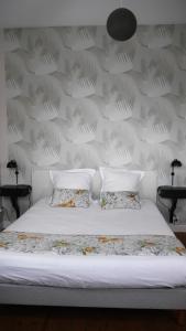 a white bed with two pillows and a wall at Maison Castel Braz in Pont-Aven