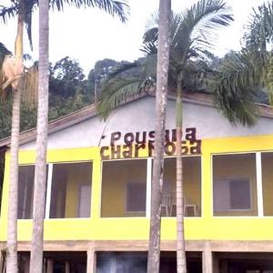 a yellow and white building with palm trees in front of it at POUSADA CHARMOSA in Superagui