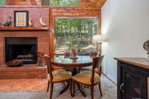 comedor con mesa y chimenea en Luxury Rock Creek Cabin w Deck by Lake Hamilton, en Hot Springs