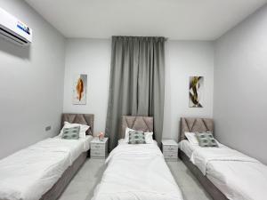 two beds in a room with white walls at alsaif camp in Bidiyah +37 photos