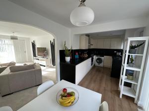 a kitchen and living room with a bowl of fruit on a table at Spacious and stylish 3-bed home ideal for families in Stockton-on-Tees