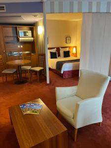 a hotel room with a bed and a chair and a table at Le Jean-Sébastien Bach in Strasbourg