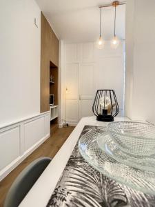 a dining room with a glass table and chairs at Appartement de charme: La rochelle/vieux port in La Rochelle