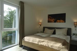 ein Schlafzimmer mit einem Bett und einem großen Fenster in der Unterkunft Familienhaus an der Nordsee - Sauna - Kamin - Südterrasse direkt über dem Wasser in Wangerland