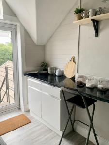 a kitchen with a black counter top and a table at Uplands & Channel View, Richmond Tce, Uplands in Swansea