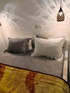 Bett mit vier Kissen in der Unterkunft Appartement haut standing avec parking gratuit in Douala