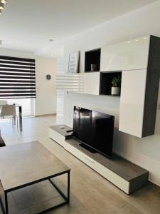 uma sala de estar com uma televisão de ecrã plano e uma mesa em Sliema, Apt7, Stylish 2 Bedroom Apartment with Parking em Sliema