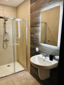 uma casa de banho com um chuveiro, um lavatório e um espelho. em Sliema, Apt7, Stylish 2 Bedroom Apartment with Parking em Sliema