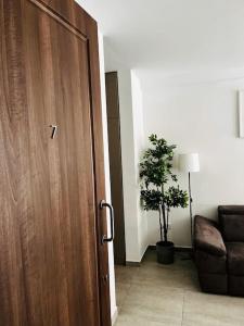 uma porta num quarto com um sofá e uma planta em Sliema, Apt7, Stylish 2 Bedroom Apartment with Parking em Sliema