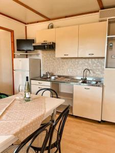 a kitchen with a table with chairs and a counter top at Agricamping Corte Pianton in Pacengo di Lazise