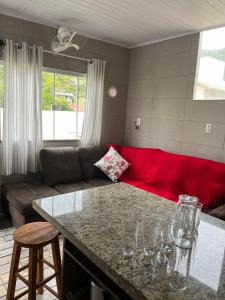 Una sala de estar con un sofá y una mesa con copas de vino. en La Lola Residencial, en Bombinhas