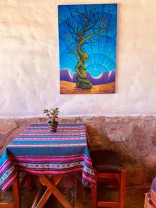 una pintura de un árbol en una pared con una mesa en Cabaña Alta Vista en Tilcara