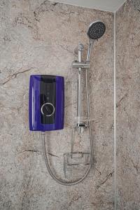 a shower with a shower head on a wall at Courtyard Bothy in Grantown on Spey