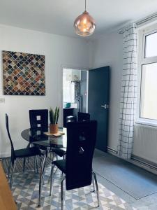 une salle à manger avec une table et des chaises noires dans l'établissement F1 16 Glanmor Cres, à Swansea