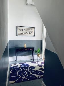 a hallway with a room with a table and a rug at F1 16 Glanmor Cres in Swansea
