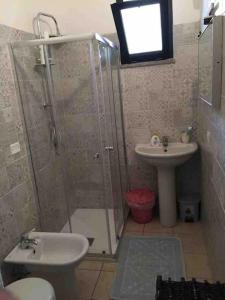a bathroom with a shower and a toilet and a sink at GIARDINI VERDI Intero appartamento in Muravera