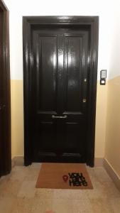 a black door with a mat in front of it at Casa Volsci, 2 camere 2 bagni, Roma centro in Rome