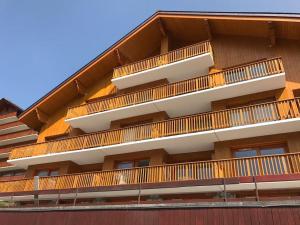 budynek z drewnianymi balkonami z boku w obiekcie Méribel 2 pièces avec cabine, centre, proche commerce et pistes avec parking et wifi état neuf w mieście Les Allues