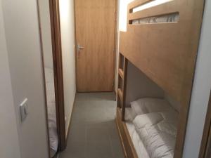 mały pokój z 2 łóżkami piętrowymi i drzwiami w obiekcie Méribel 2 pièces avec cabine, centre, proche commerce et pistes avec parking et wifi état neuf w mieście Les Allues