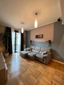 salon z kanapą i drewnianą podłogą w obiekcie Premium high floor design apartment in Città Studi w Mediolanie
