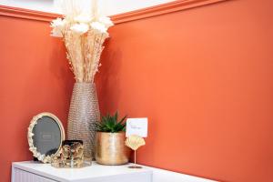 un vase sur une table avec un miroir et des fleurs dans l'établissement Paris Homestay of Happyness, au Kremlin-Bicêtre