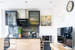 a kitchen with a counter and a clock on the wall at Paris Homestay of Happyness in Le Kremlin-Bicêtre