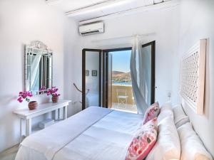 Biała sypialnia z łóżkiem i balkonem w obiekcie Villa Light w mieście Vourkari