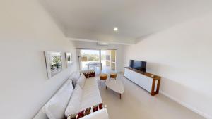 a living room with a couch and a tv at Terrazas de la Viuda in Punta Del Diablo