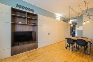 Un comedor con una mesa y un televisor de pantalla plana. en Easylife - Milano - Crocetta 2 P1D - Porta Romana, en Milán