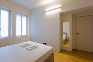 1 dormitorio blanco con 1 cama con 2 toallas en Easylife - Spazioso e tranquillo trilocale in Porta Romana, en Milán