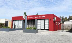 a red building with a sign that reads aark las turns at Apart Las Tunas Carmelo in Carmelo