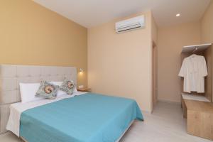 a bedroom with a blue bed with pillows and a closet at Spartakos Luxury Villa 6 in Plános