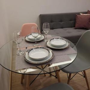 una mesa de cristal con platos y copas de vino. en Choita hospedaje. Hermosa suite en la Carolina, en Quito