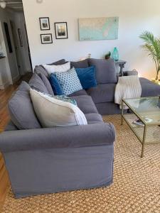 - un canapé bleu dans le salon avec une table dans l'établissement Downtown- Sunshine Cottage and Golf Cart, à Southport