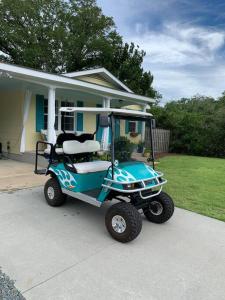 une voiturette de golf garée devant une maison dans l'établissement Downtown- Sunshine Cottage and Golf Cart, à Southport