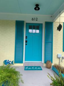 une porte d'entrée bleue d'une maison avec dans l'établissement Downtown- Sunshine Cottage and Golf Cart, à Southport