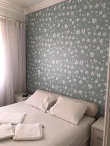 a bedroom with a bed with a floral wallpaper at Aconchego da Helo in Mariana