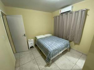 - une petite chambre avec un lit et une fenêtre dans l'établissement Moradas Pará Satélite 303, à Belém
