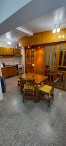 Un comedor con mesa y sillas de madera. en Kennedy 5, en San Rafael 2 fotos más