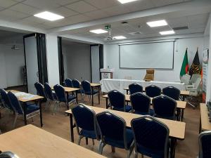 una clase con mesas, sillas y una pantalla blanca en Atlantis Air de France - Alger en Bouzareah