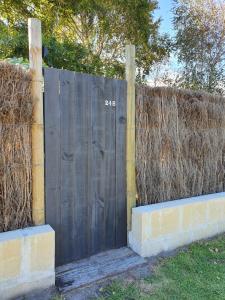 a wooden gate with the on it next to a fence at Brushwood Studio in Denmark