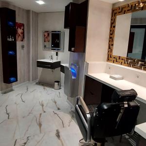 a bathroom with a sink and a chair in it at Atlantis Air de France - Alger in Bouzareah