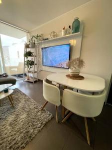 イキケにあるCondominio Playa Huantajayaのテーブルと椅子とテレビのあるリビングルーム
